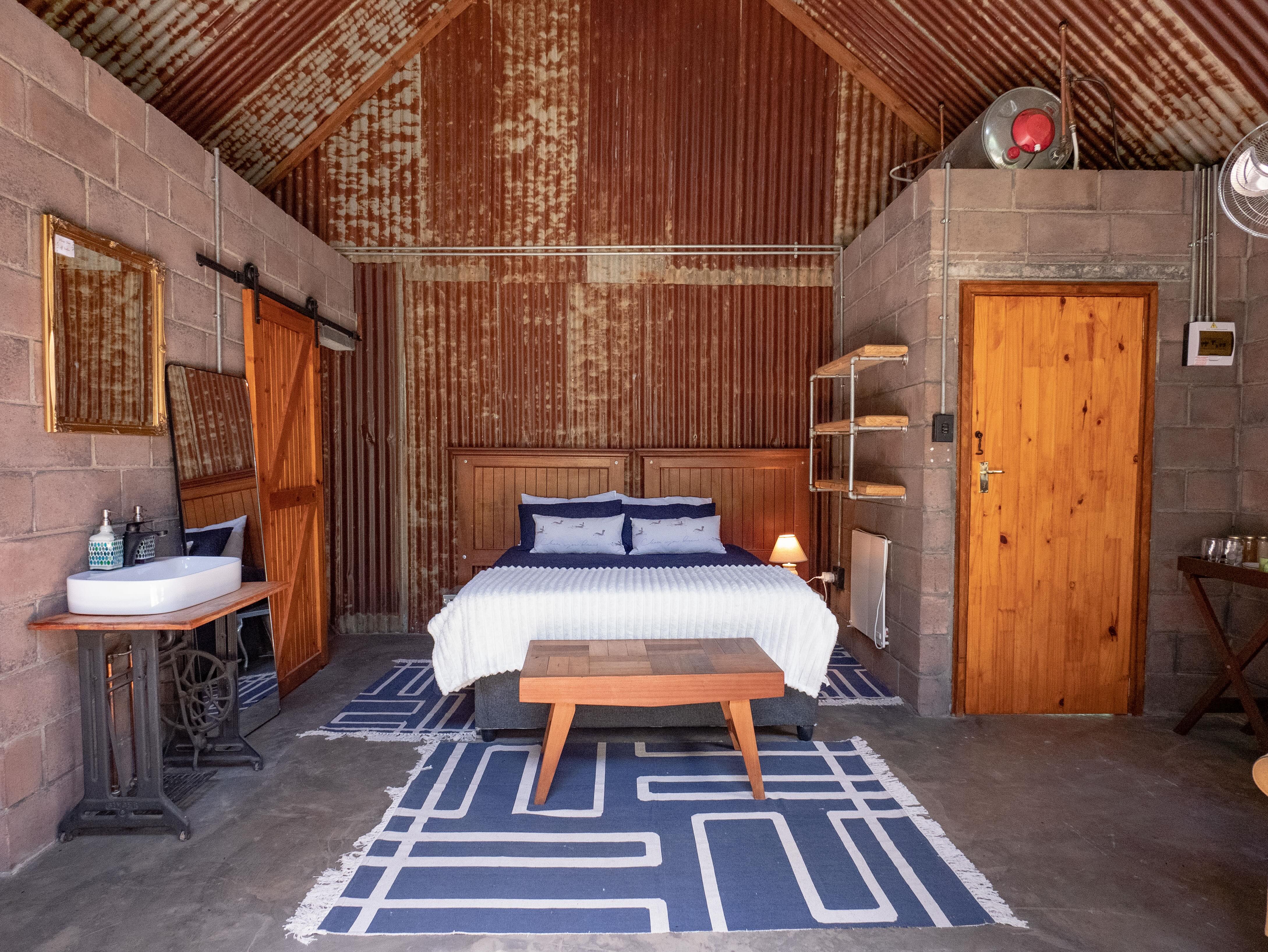 Cottage bedroom with blue bedding and corrugated iron