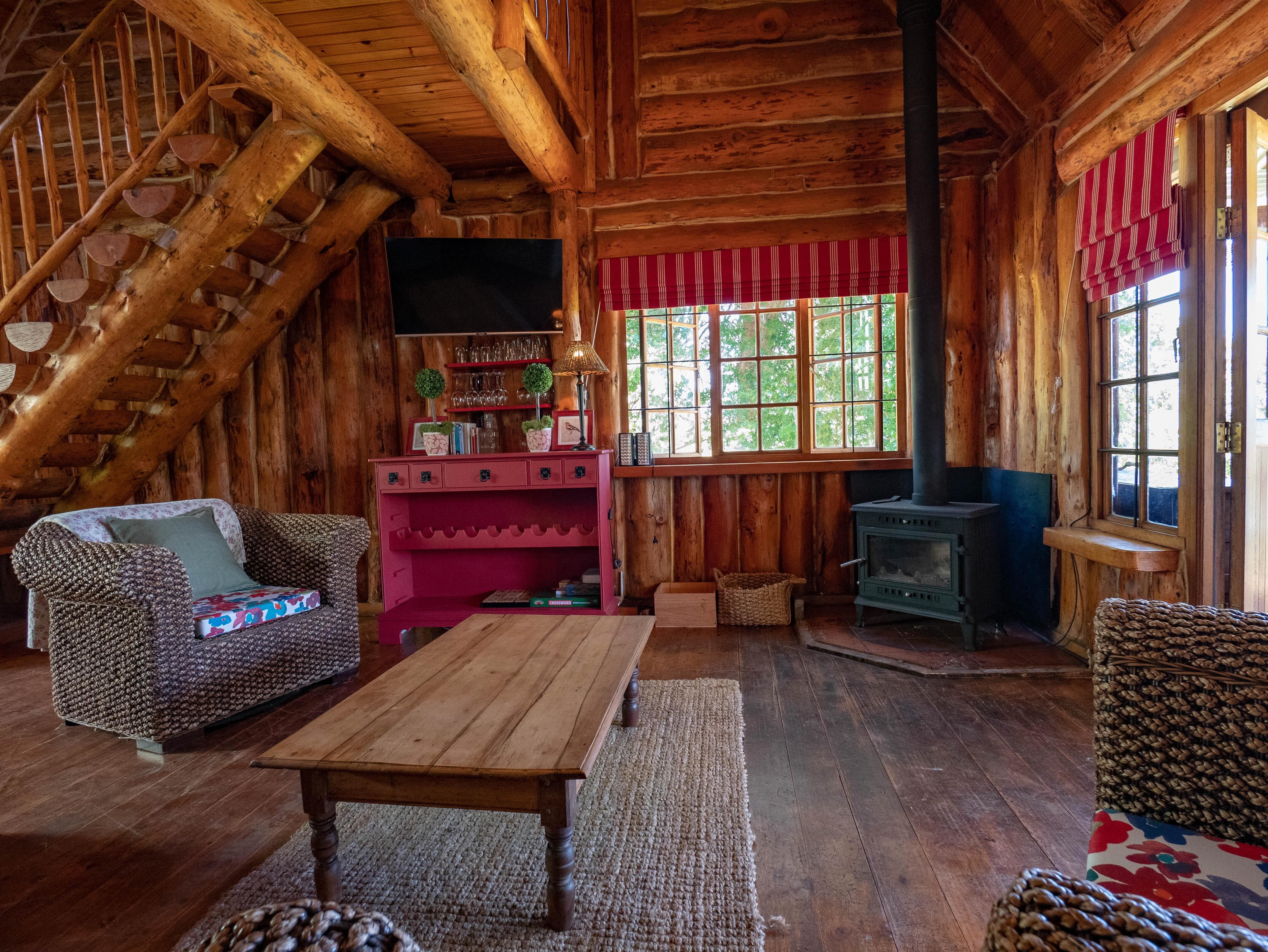 Log cabin lounge with rattan chairs and log burner