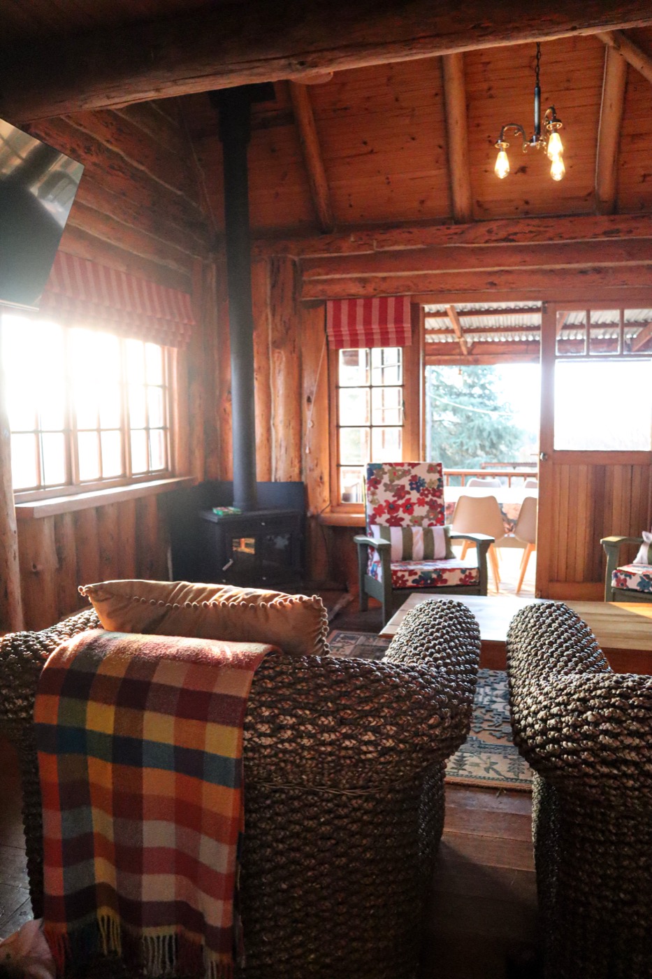 Log cabin lounge with wood-burning fireplace and winter light