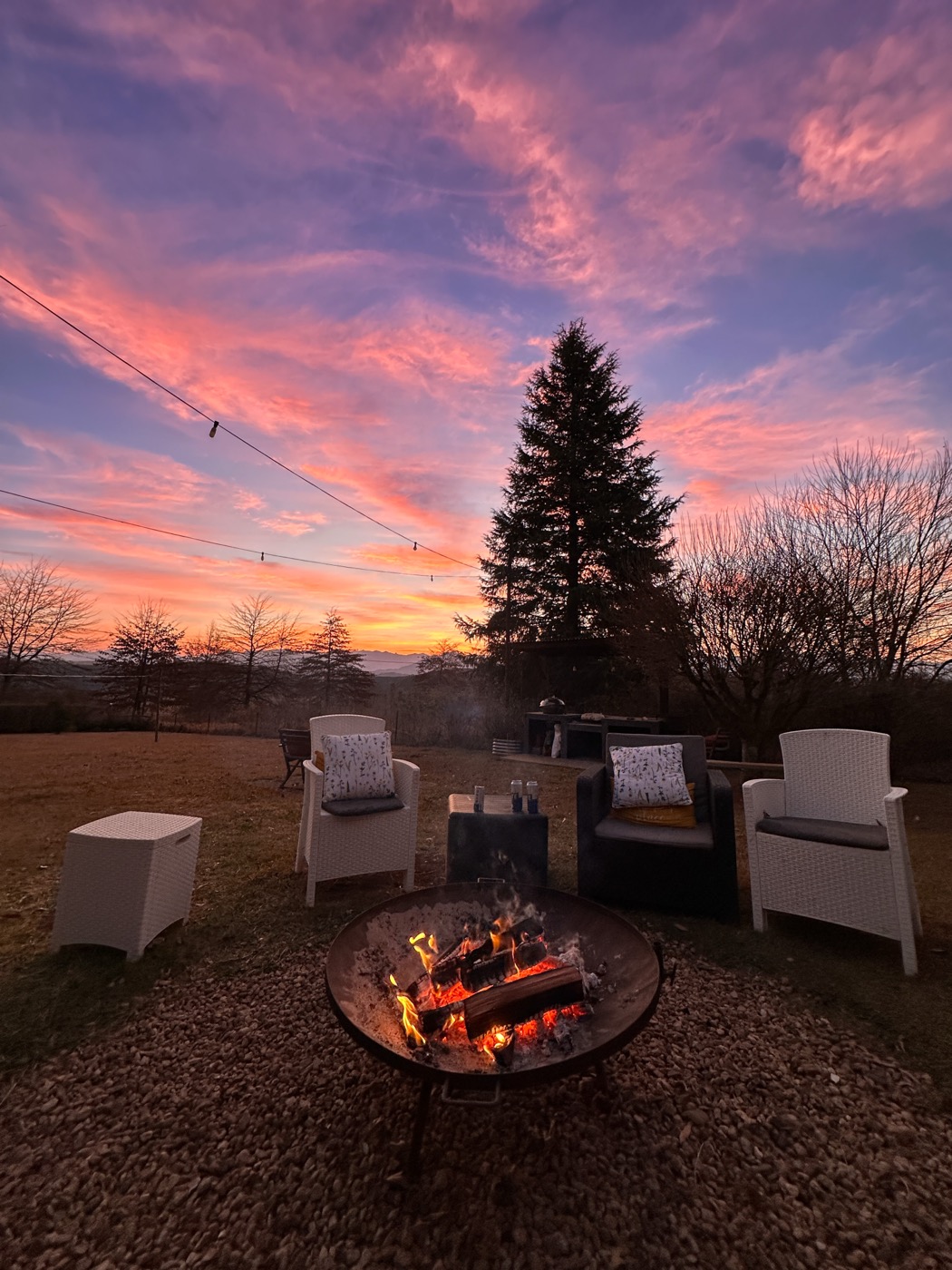 Firepit burning under a pink winter sunset at Oakhaven